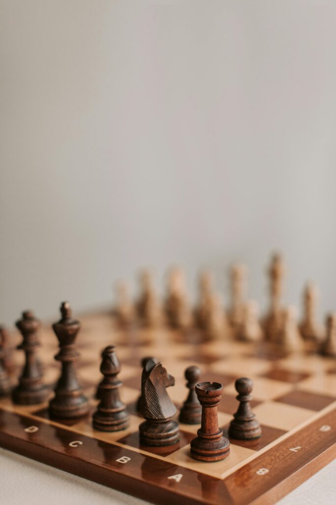 Close-up of arranged chess pieces on a chessboard highlighting strategy and focus.